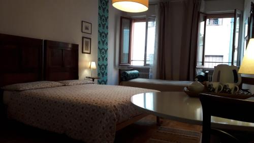 a bedroom with a bed and a table and a couch at B&B Barberia in Treviso