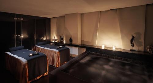 a room with two tables and a tub with lights at The Canvas Dubai - MGallery Hotel Collection in Dubai