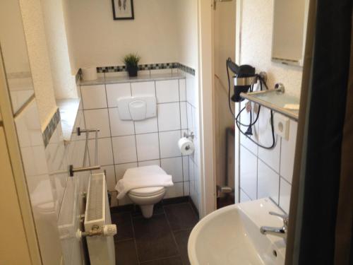 a small bathroom with a toilet and a sink at Hotel Saarland Lebach in Lebach