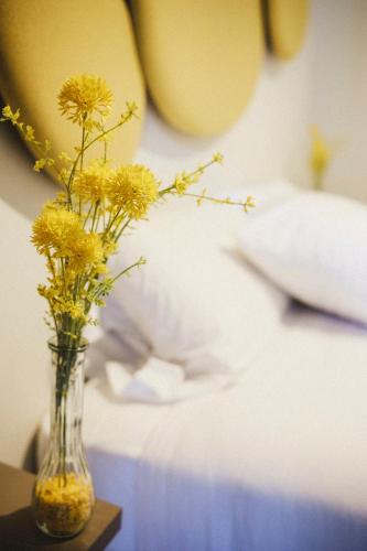 a vase filled with yellow flowers sitting on a table at Smart Urban Orio in Orio