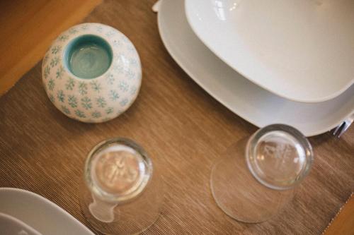 a table with plates and a vase and glasses on it at Smart Urban Orio in Orio