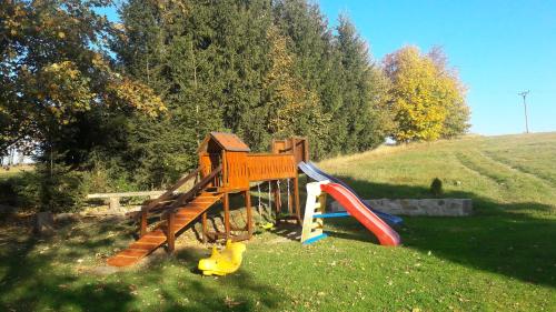 a playground with a slide in the grass at Chalupa Háj in Jindřichovice