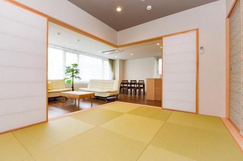 Habitación con puertas correderas y sala de estar. en Ryo An en Otaru