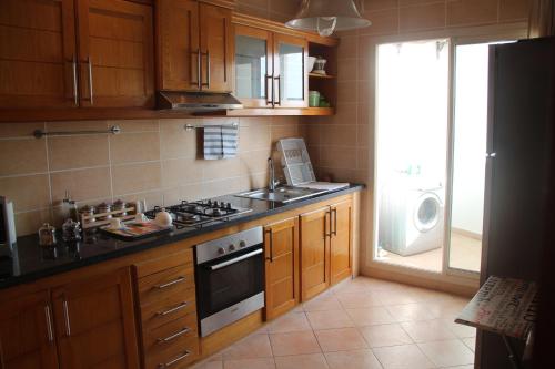 a kitchen with a stove and a sink and a refrigerator at Airport to Comme à la maison 1 in Nouaseur