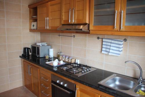 a kitchen with a stove top oven next to a sink at Airport to Comme à la maison 1 in Nouaseur