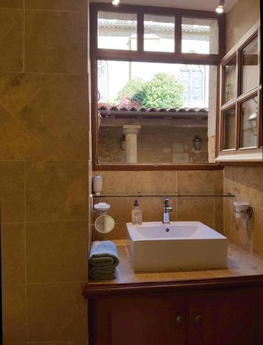 une salle de bain avec un lavabo et une fenêtre dans l'établissement Appartement Le Cardinal, à Sarlat-la-Canéda
