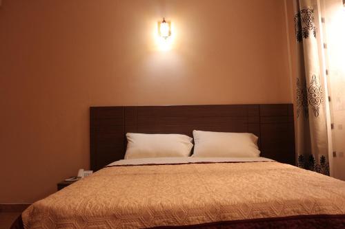 a bedroom with a large bed with a brown headboard at Agenda 2000 Hotels Ltd in Kampala