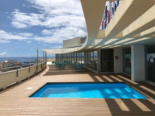 a beach with a balcony overlooking the ocean at VIP Executive Azores Hotel in Ponta Delgada