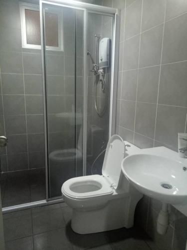 a bathroom with a shower and a toilet and a sink at Casarozza Homestay, Southville City in Bangi