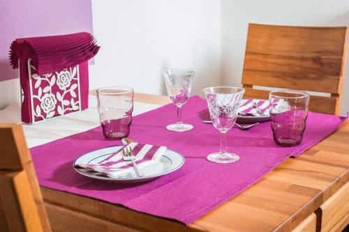 a table with a purple table cloth with plates and glasses at Ferienwohnung Küssner in Kiel