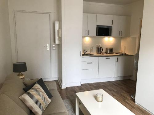 a living room with a couch and a kitchen at Appartement cœur de la bastille in Paris