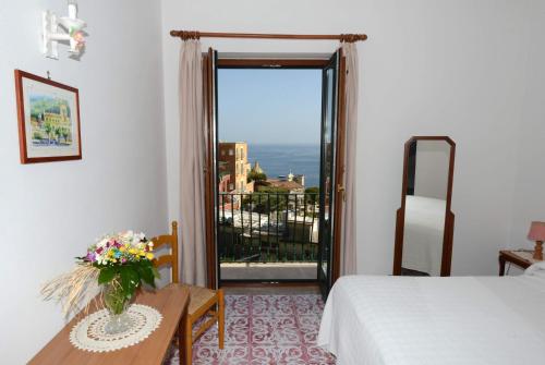 a bedroom with a bed and a table and a window at Villa Maria Antonietta in Positano