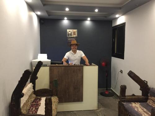 a man is standing behind a desk in a room at H100 Pyramids View in Giza