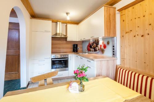 a kitchen with a table with a vase of flowers on it at Ferienwohnungen Lechthaler in Wenns