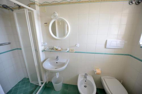 a bathroom with a sink and a toilet and a mirror at Villa Maria Antonietta in Positano