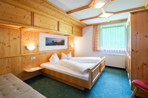 a bedroom with a large bed in a wooden room at Ferienwohnungen Lechthaler in Wenns
