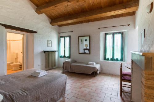 フォルリにあるAgriturismo La Lenticchiaのベッドルーム1室(ベッド1台、ソファ、窓付)