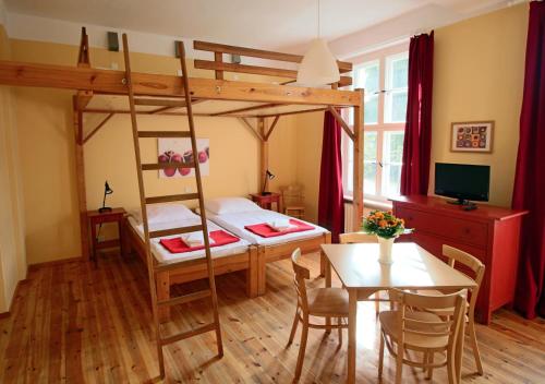 a bedroom with a bunk bed and a table and a dining room at Familien- und Freizeithotel Gutshaus Petkus in Petkus