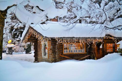 a log cabin covered in christmas lights in the snow at Le Grand Bellevue in Gstaad