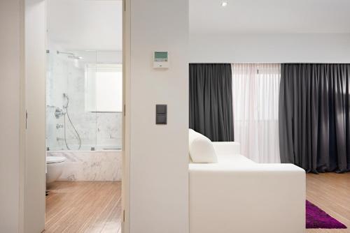 a white bathroom with a toilet and a sink at Hotel dos Zimbros in Sesimbra