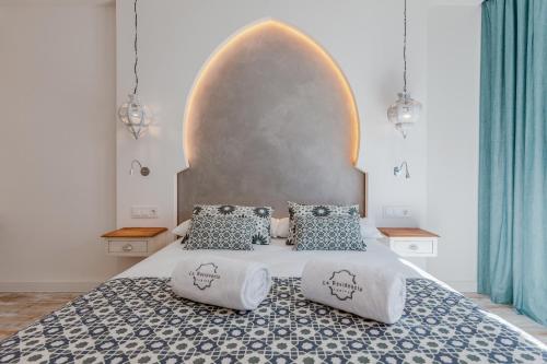 a bedroom with a large bed with two pillows at La Residencia Puerto Hotel & Spa in Tarifa