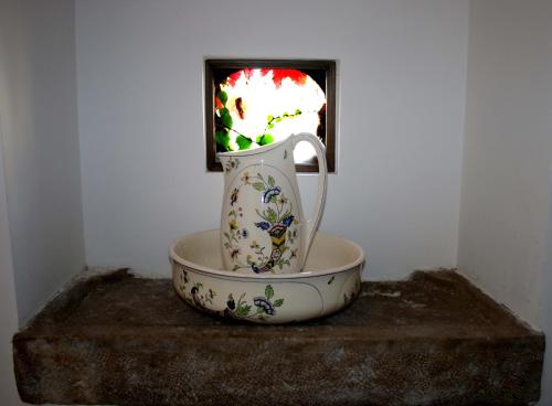 a vase sitting in a bowl on a table at Au Relais de Nèche. in Bègues