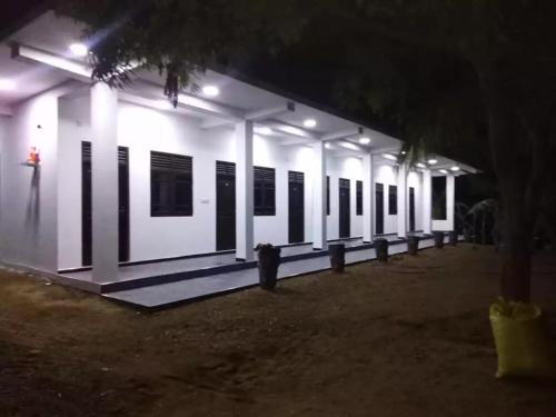 a white building with black windows at night at Quench Inn in Ampara