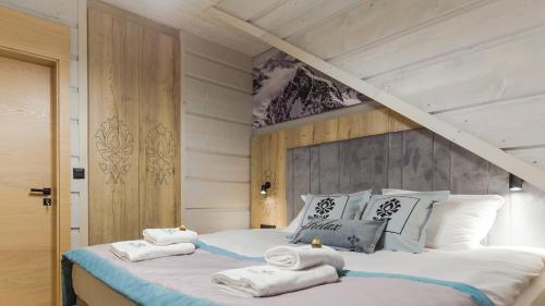 a bedroom with a bed with towels on it at Skansen Holiday in Cholerzyn