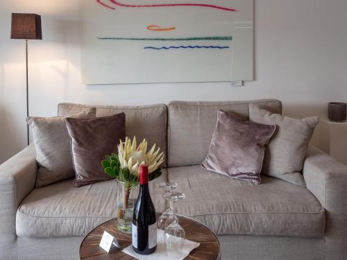 a living room with a couch and a table with a bottle of wine at Boutique Hotel Villa Monika in Westerland (Sylt)