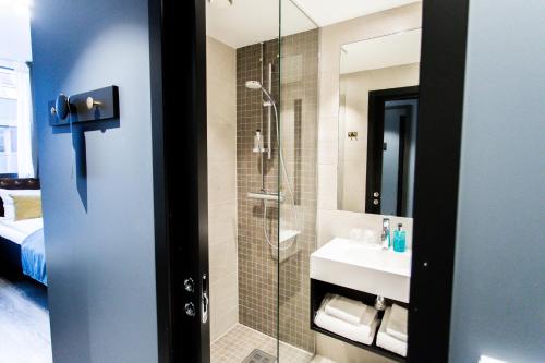 a bathroom with a shower and a sink at The Verdandi Hotel in Oslo