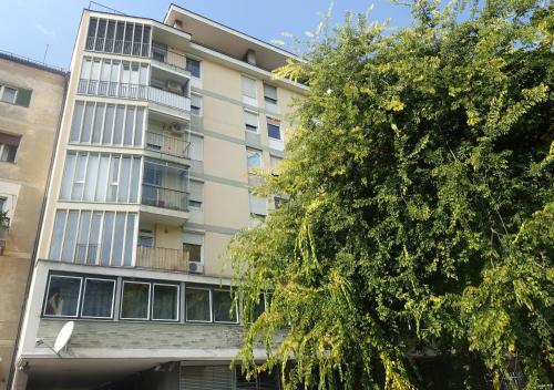 an apartment building with a tree in front of it at Atelier Hotel in Ljubljana