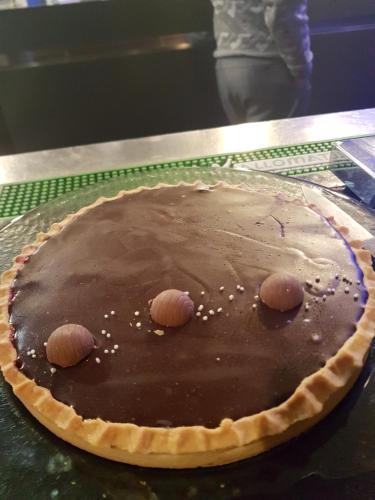 巴黎Hotel PARIS GAMBETTA- PANAMHOTEL-PERE LACHAISE的坐在桌子上的一个巧克力派