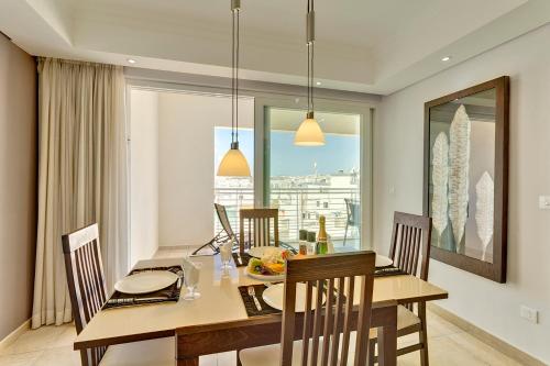 a dining room with a table and chairs and a window at Luxury Apartment inc Pool & Views in Sliema