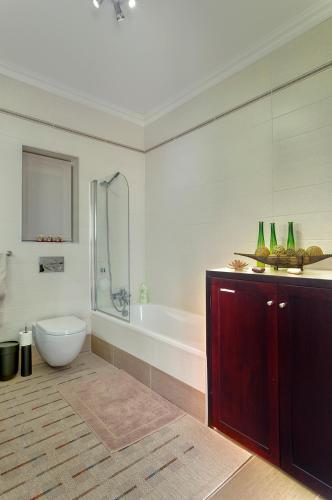 a bathroom with a tub and a toilet and a sink at Luxury Apartment inc Pool & Views in Sliema