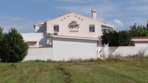 a white house with graffiti on the side of it at Les Casetes de Camarles in Camarles