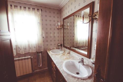 a bathroom with two sinks and a mirror at Les Casetes de Camarles in Camarles