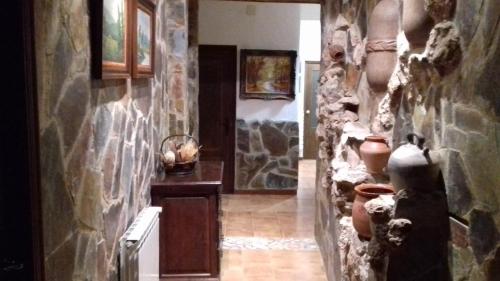 a hallway with stone walls and pots on the wall at Les Casetes de Camarles in Camarles