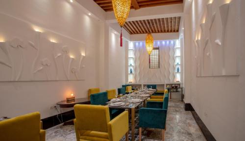 een eetkamer met een lange tafel en stoelen bij La Maison Maure in Fès