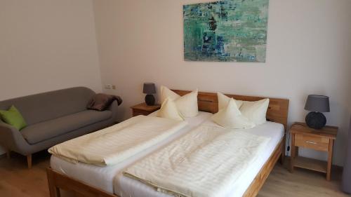 a bedroom with a bed and a couch at Appartementhaus Wimmerhof in Bad Füssing