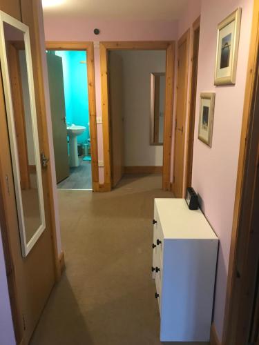 a room with a white counter and a hallway at 3 coach house balnagown in Tain