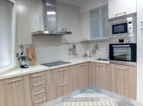 a kitchen with wooden cabinets and a stove top oven at Apartamento centrico en Lekeitio, playa y puerto in Lekeitio