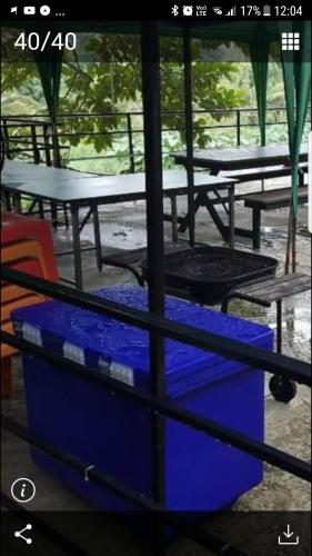 a group of picnic tables and a blue cooler at Kaengkrachan River Hut in Kaeng Krachan