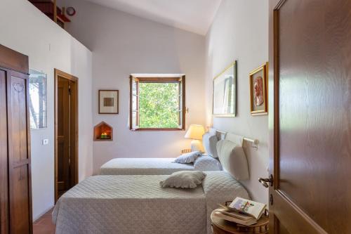 a small bedroom with two beds and a window at Podere Le Capannucce in Pontedera