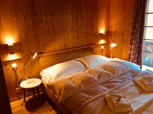 a bedroom with a large bed with a wooden wall at Chalet Steinböckle****S in Saas-Fee