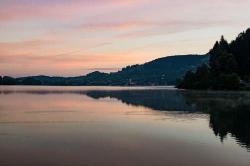 a view of a lake at sunset at Appartementhaus „die Kuh am See“ (vormals Haus St. Leonhard) in Schliersee