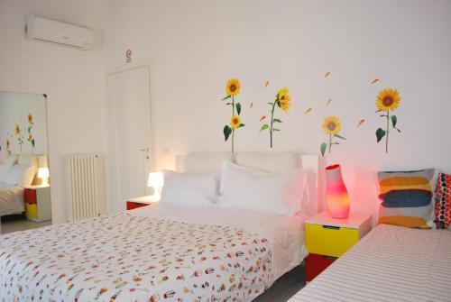 a bedroom with a bed with sunflowers on the wall at Appartamento Annurca in Naples