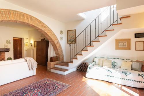 a living room with a white couch and stairs at Podere Le Capannucce in Pontedera