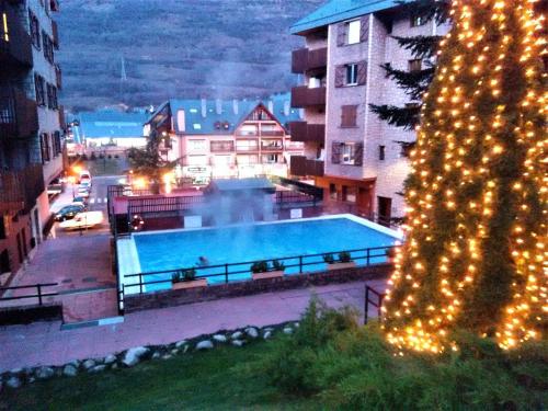 a christmas tree with lights next to a swimming pool at VIELHA VII in Vielha