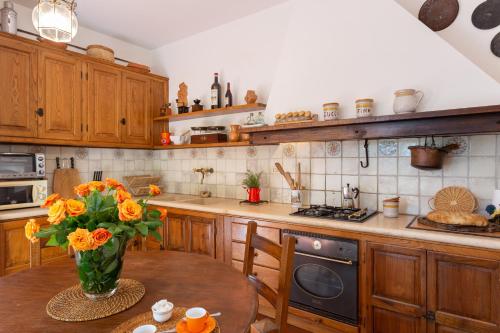a kitchen with a vase of flowers on a table at Podere Le Capannucce in Pontedera