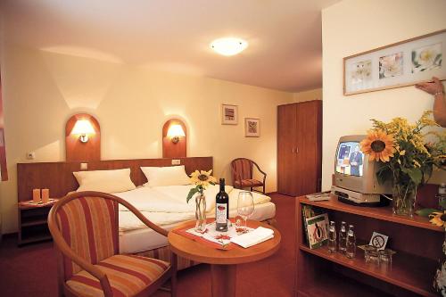 a hotel room with a bed and a table with a television at Landgasthof Zur Tanne in Waltershausen